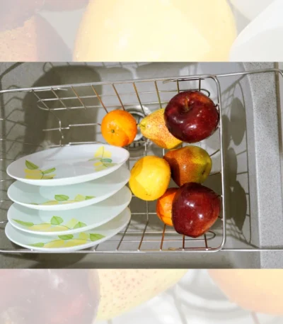 Stainless steel sink basket with sturdy handles for easy lifting and portability.