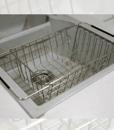 Adjustable over-the-sink dish drying basket for easy utensil storage.